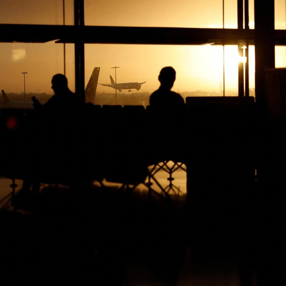 Passengers wait in the departures area as a commercial plane lands at London Heathrow Airport on Nov 15, 2025. 