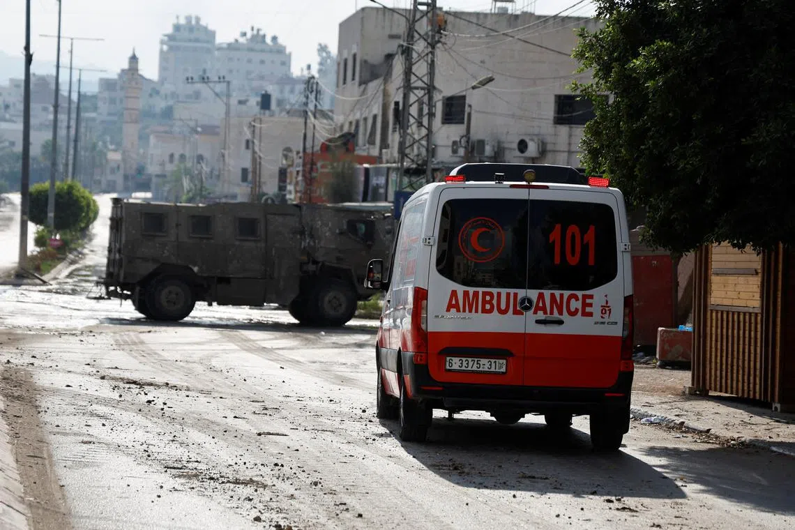 An ambulance is seen as a military vehicle operates during an Israeli raid in Tulkarm, in the Israeli-occupied West Bank, July 23, 2024. REUTERS/Raneen Sawafta