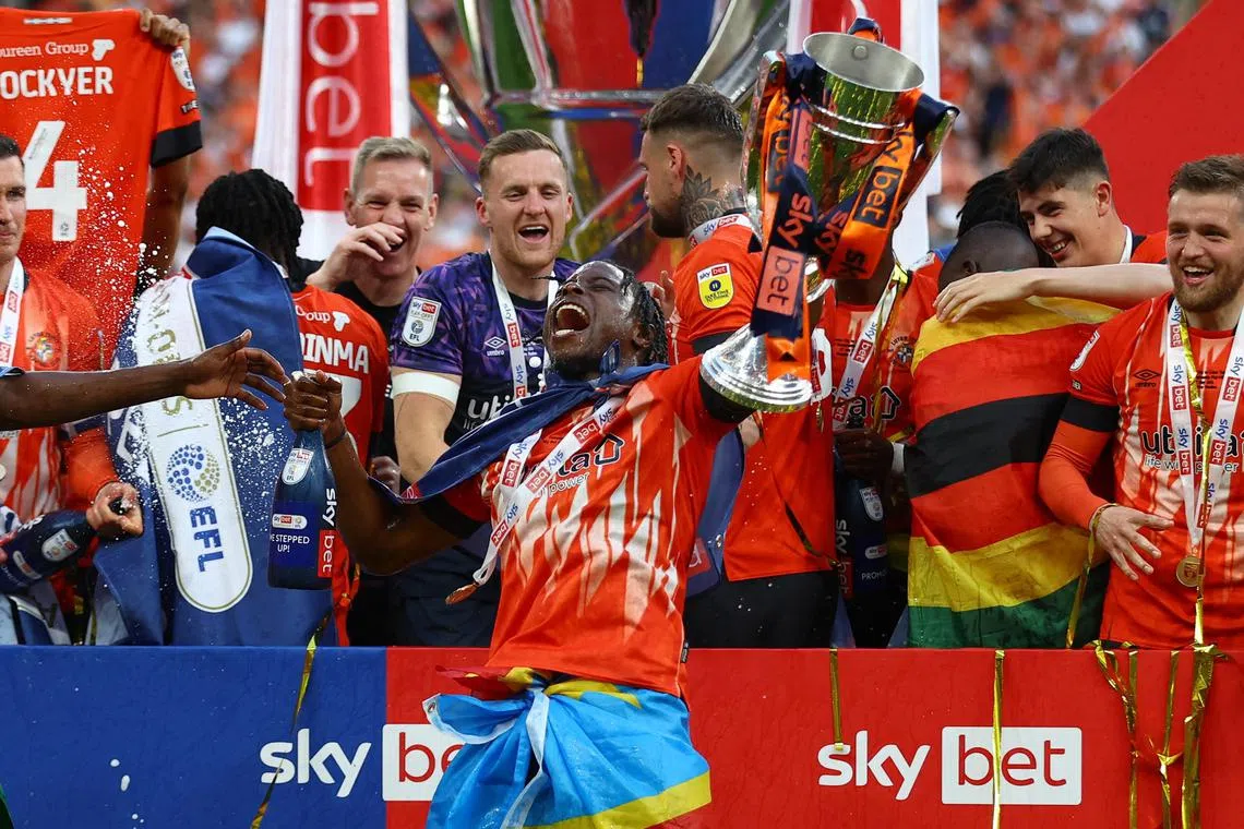 Luton Town's Pelly-Ruddock Mpanzu celebrates with the trophy after winning the Championship Play-Off Final.