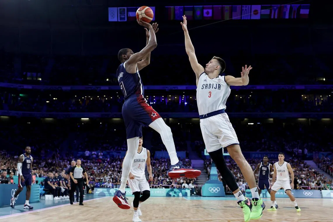 Kevin Durant of US (left) in action against Filip Petrusev of Serbia during the Olympics' basketball competition.