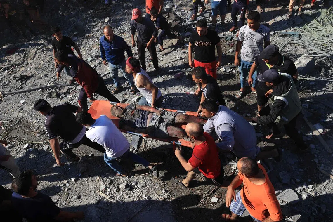 A Palestinian is stretchered away after being pulled out from under the rubble of a building following an Israeli airstrike in Rafah, on Oct 16, 2023.