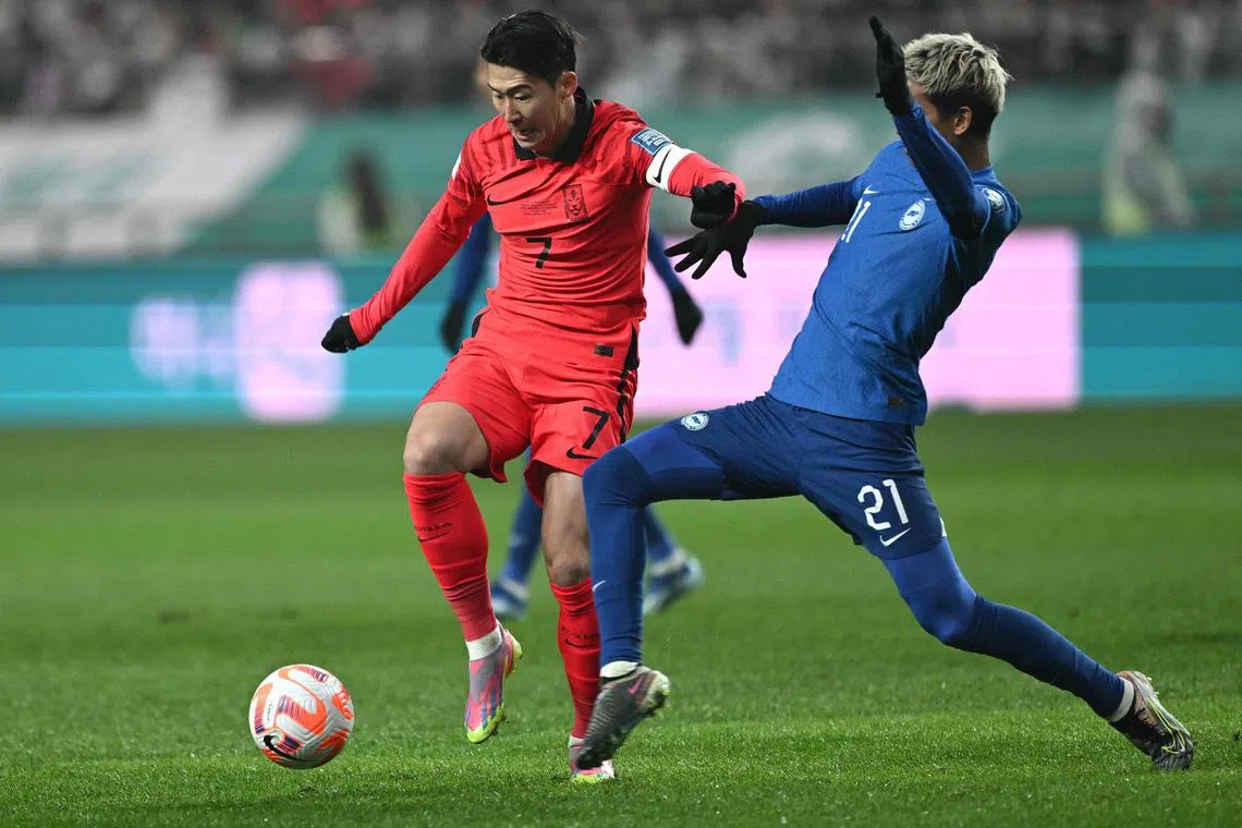 South Korea forward Son Heung-min fights for the ball with Singapore defender Muhammad Safuwan Baharudin during a 2026 World Cup qualification match in November 2023.