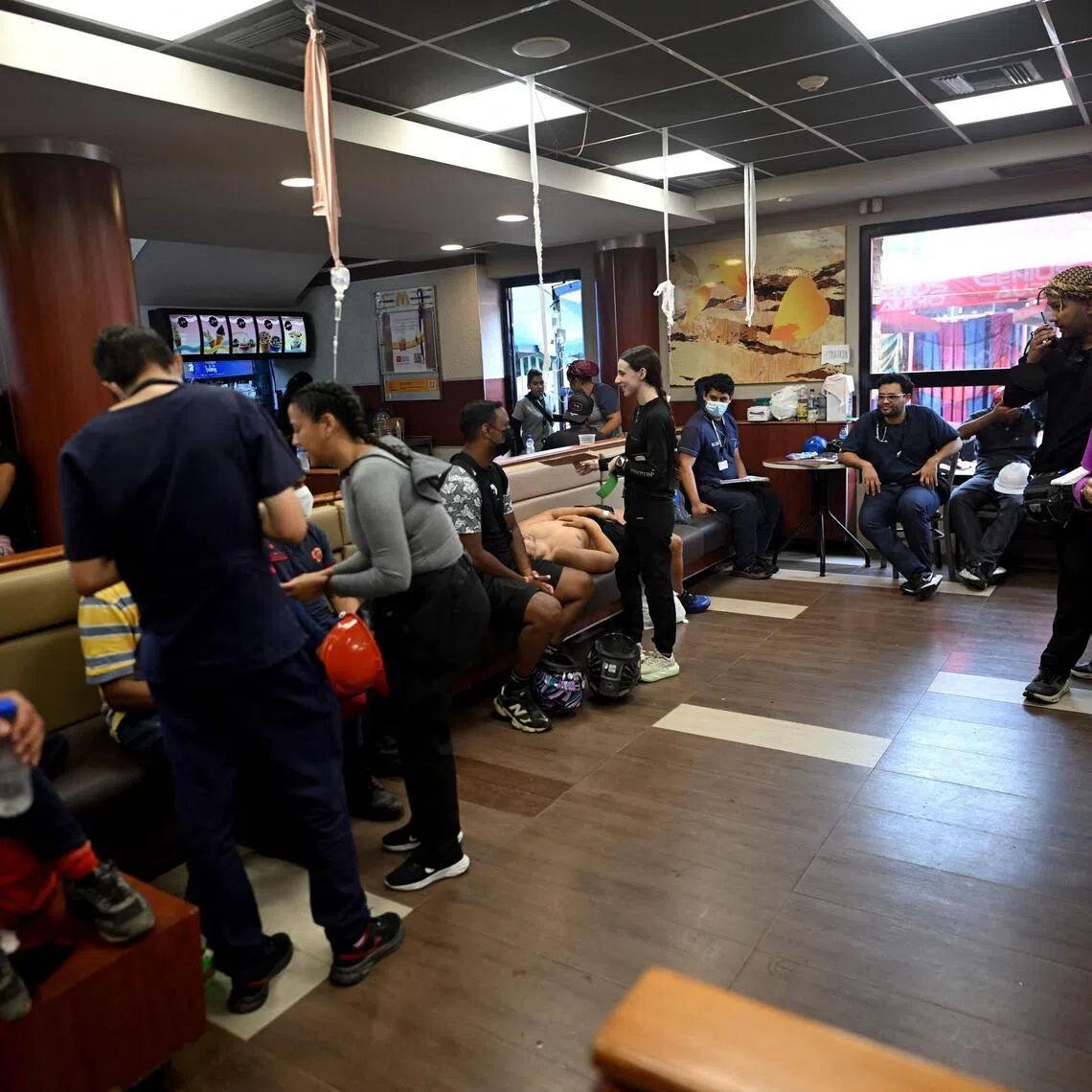 Health workers tend to people inside a McDonald’s restaurant operating as a medical care center following twin earthquakes in Caraballeda, Venezuela, on July 3.