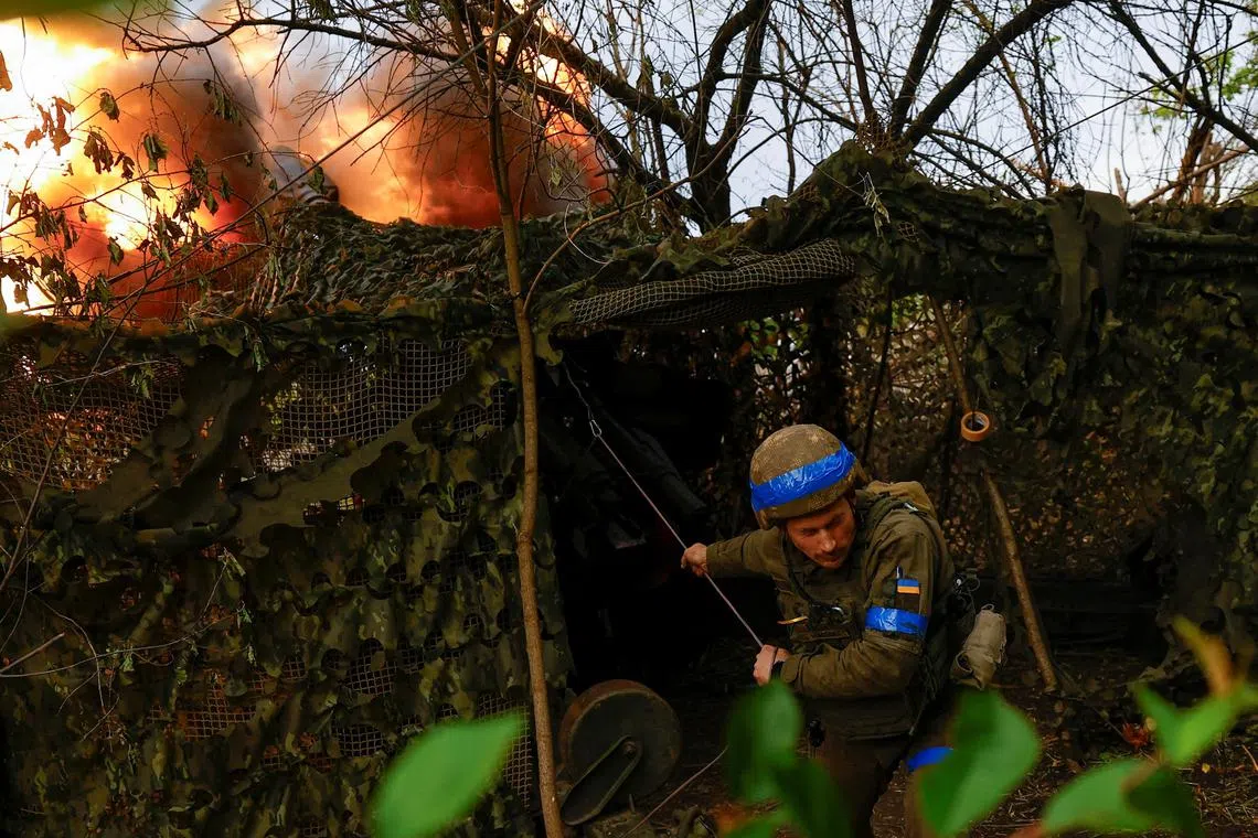 A Ukrainian serviceman fires a howitzer at Russian positions in Ukraine's Kharkiv region.