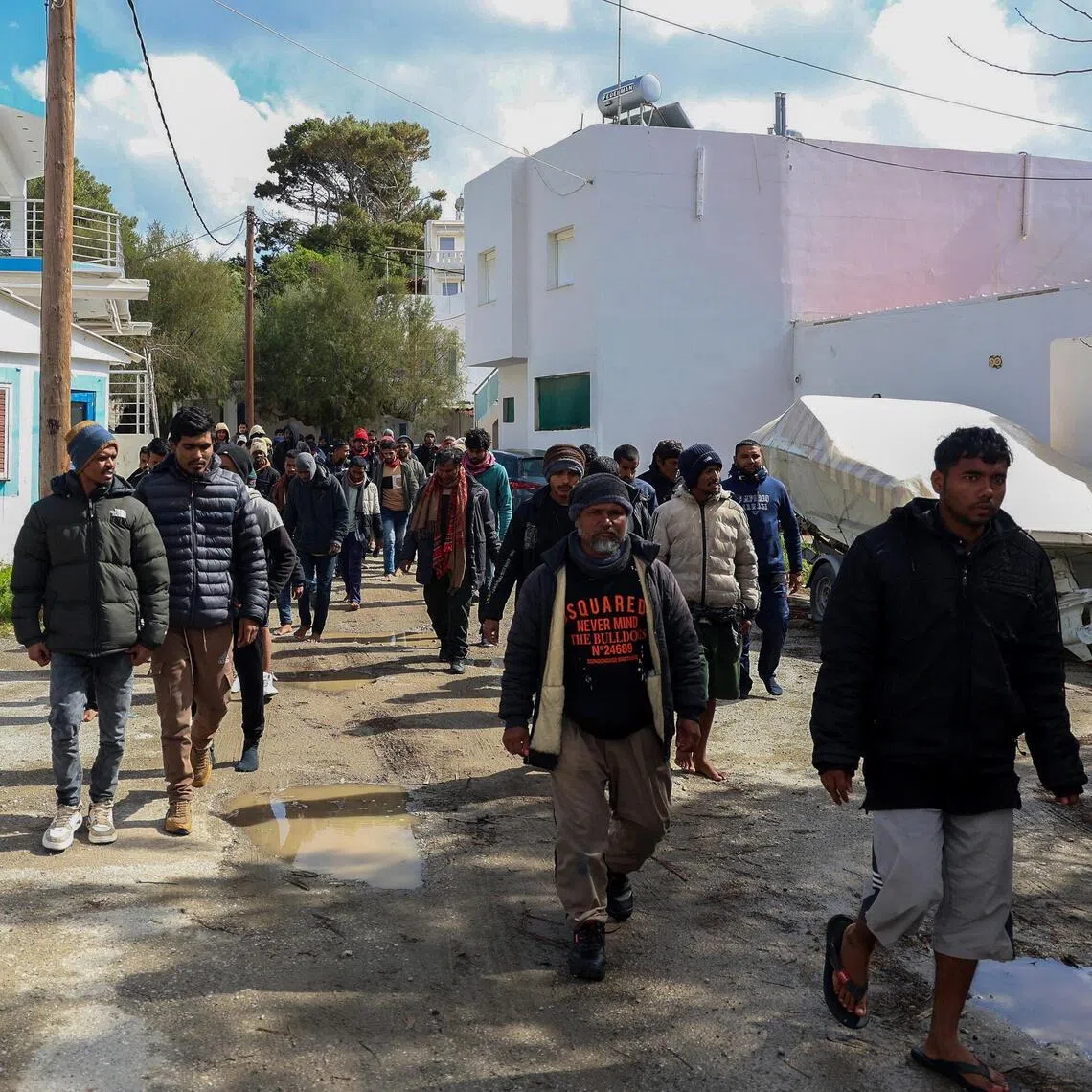 Migrants walk through the village of Kaloi Limenes, on the island of Crete, Greece, February 21, 2026. REUTERS/Stefanos Rapanis