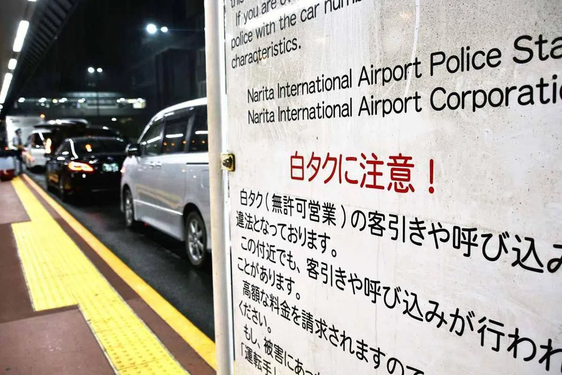 A sign warning against the use of unlicensed taxi services is seen at Narita Airport.