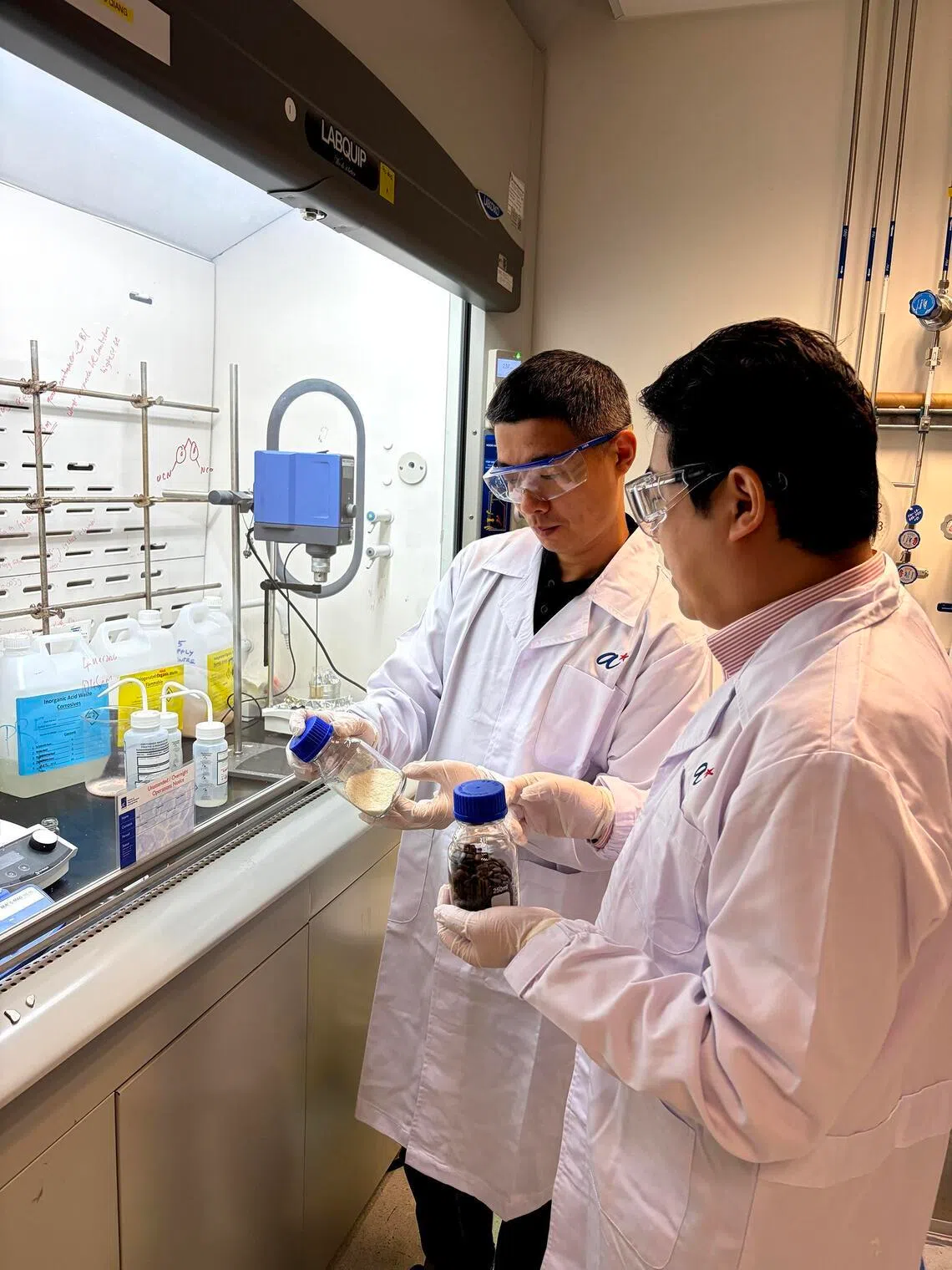 Dr Kai Dan (left) and Dr Zhu Qiang from the A*STAR Institute of Materials and Research Engineering with samples of treated spent coffee grounds and bio-based heat-absorbing materials from the project.