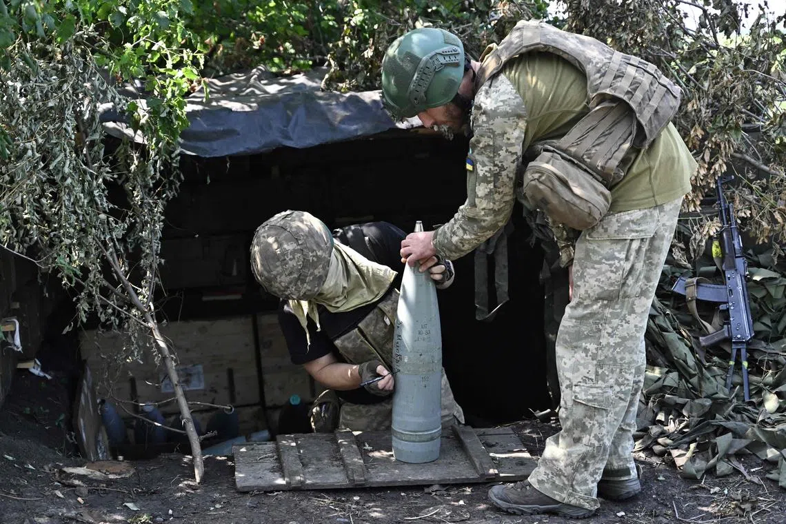 TOPSHOT - Ukrainian artillerymen prepare 152 mm projectiles for artillery at a position on the front line near Bakhmut, eastern Ukraine, on July 20, 2023, amid the Russian invasion of Ukraine. (Photo by Genya SAVILOV / AFP)