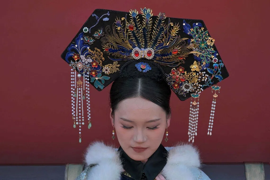 A woman dressed in Qing Dynasty imperial costume is pictured as people visit the Forbidden City in Beijing on Decr 21, 2025. 