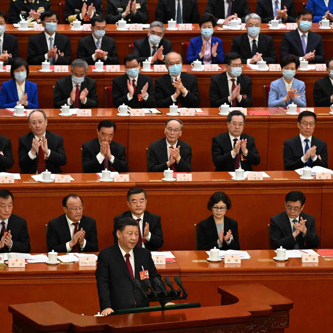 China's President Xi Jinping (front) speaks during the closing session of the National People's Congress at the Great Hall of the People in Beijing, on March 13, 2023. 