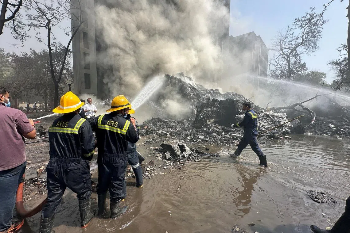 Rescue team members work as smoke rises at the site where an Air India plane crashed in Ahmedabad, India, June 12, 2025. REUTERS/Amit Dave