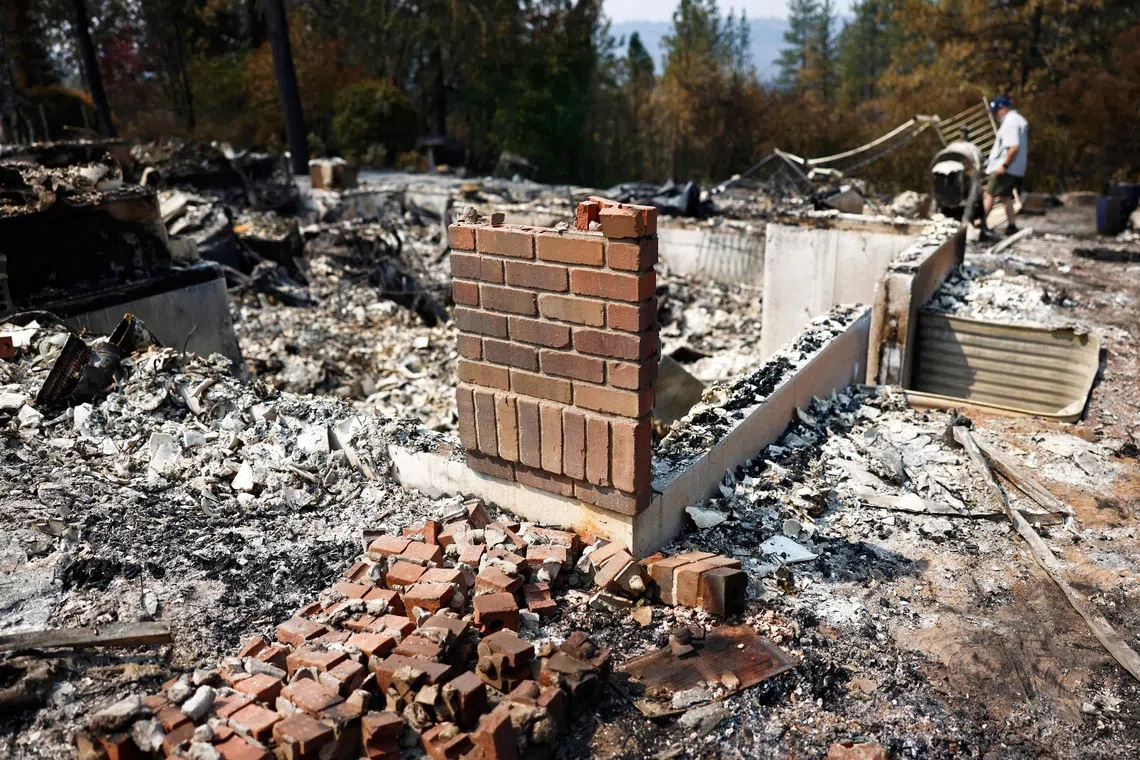 SPOKANE, WASHINGTON - AUGUST 06: Jim Zimmer searches through the remains of his home which was destroyed in the Old Trails Fire on August 6, 2026 in Spokane, Washington. Fueled by strong winds amid drought, fast-moving wildfires burned over 10,000 acres combined in the Spokane area over the weekend, destroying more than 700 structures, including many homes. 65,000 people were forced to evacuate, and one man was arrested on suspicion of first-degree arson in the Old Trails Fire.   Mario Tama/Getty Images/AFP (Photo by MARIO TAMA / GETTY IMAGES NORTH AMERICA / Getty Images via AFP)