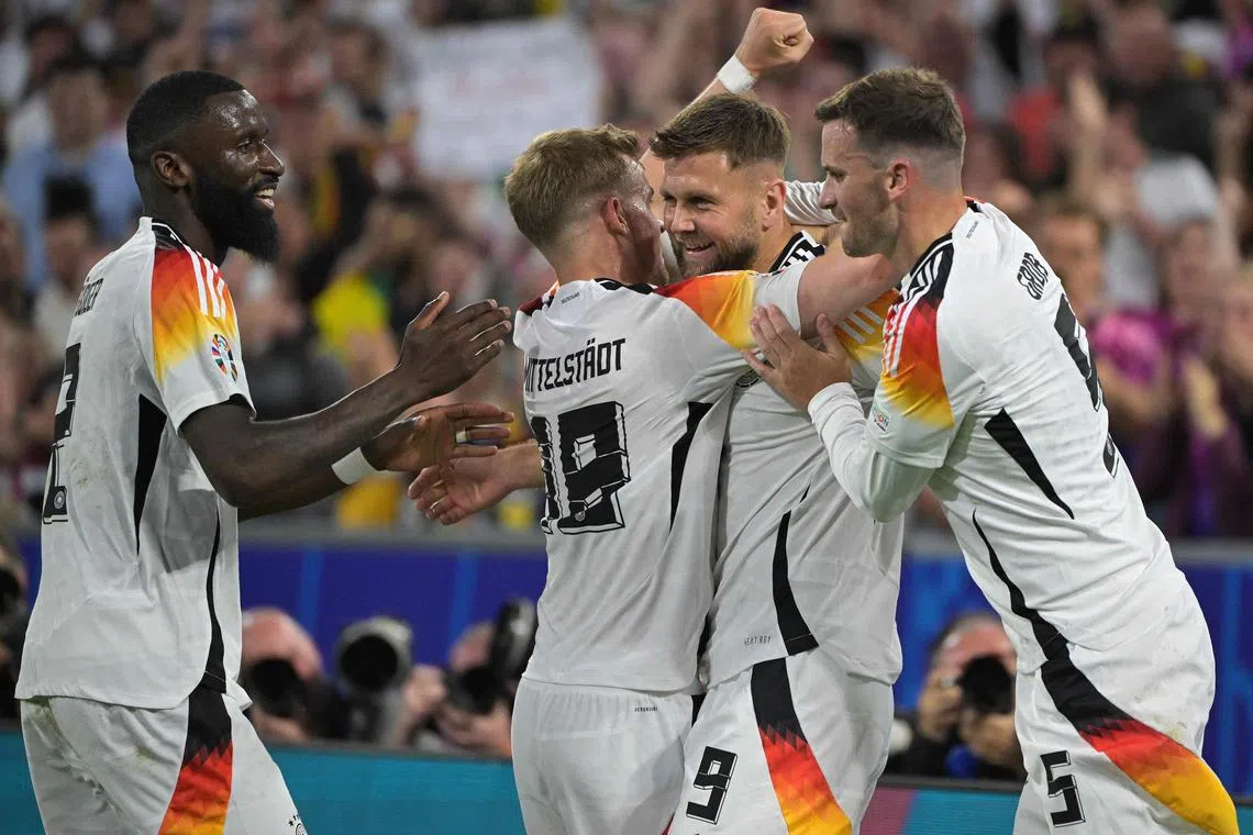 Germany forward Niclas Fuellkrug (centre right) celebrates with teammates after scoring his team's fourth goal.