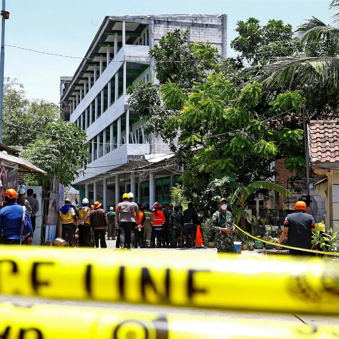 Rescuers gather near the site of a building collapse on Monday, where people remained trapped according to disaster mitigation agency, as the search and rescue operations continue at Al Khoziny Islamic boarding school in Sidoarjo, East Java province, Indonesia, October 2, 2025. REUTERS/Dipta Wahyu