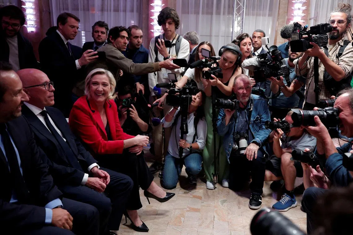 French far right leader Marine Le Pen, Eric Ciotti, contested leader of French conservative party Les Republicains (The Republicans - LR), and Sebastien Chenu, vice-president of the French far-right National Rally (Rassemblement National - RN) party are surrounded by journalist before a press conference by Jordan Bardella, President of the Rassemblement National party, to present policy priorities as part of the campaign for the upcoming French parliamentary elections, in Paris, France, June 24, 2024. REUTERS/Gonzalo Fuentes
