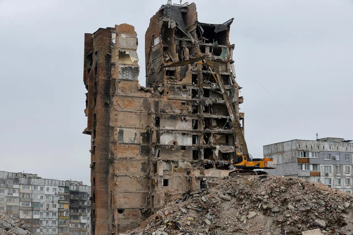 FILE PHOTO: An xcavator demolishes a multi-storey apartment block, which was destroyed in the course of Russia-Ukraine conflict, in Mariupol, Russian-controlled Ukraine, March 16, 2023. REUTERS/Alexander Ermochenko/File Photo