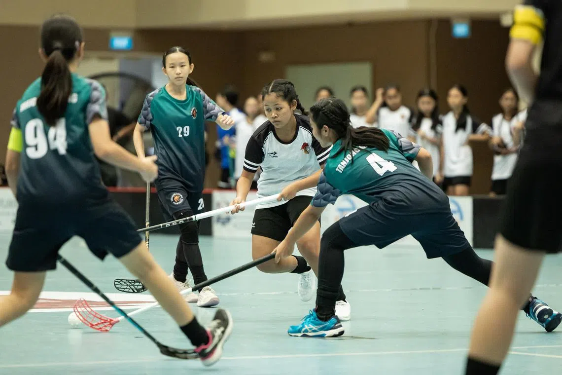 St Hilda's Secondary School's Nur Anniqa Irtysha Muhammad Rafie (second from right) in action against Tanjong Katong Secondary School during the girls' C Division floorball final on Sept 2.