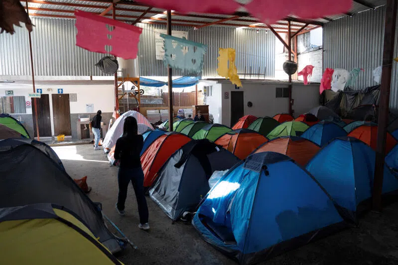 Migrants walk past partially empty tents at the shelter, where they are staying as they wait to cross into the US, in Tijuana, Mexico.