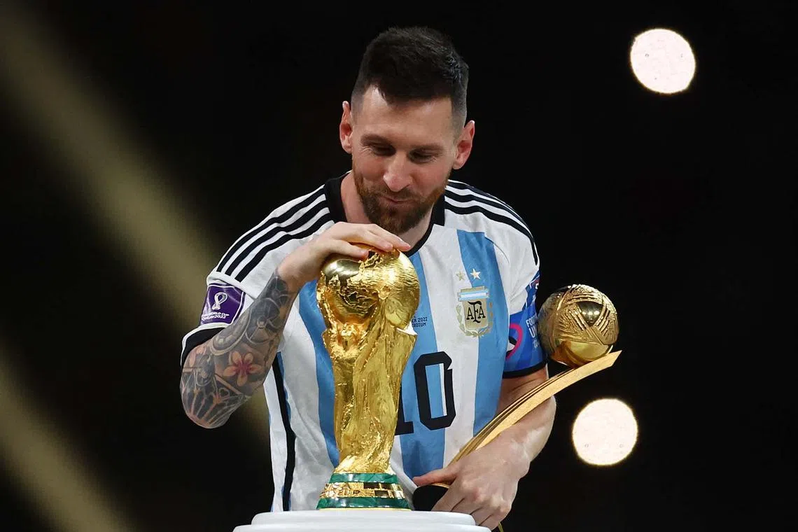 Argentina's Lionel Messi touches the World Cup trophy after receiving the Golden Ball award as he celebrates after winning the World Cup.