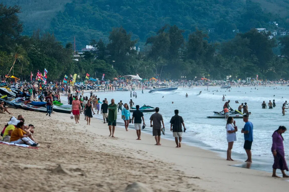 FILE PHOTO: Tourists gather at Patong beach in Phuket, Thailand, November 22, 2024. REUTERS/Napat Wesshasartar/File Photo