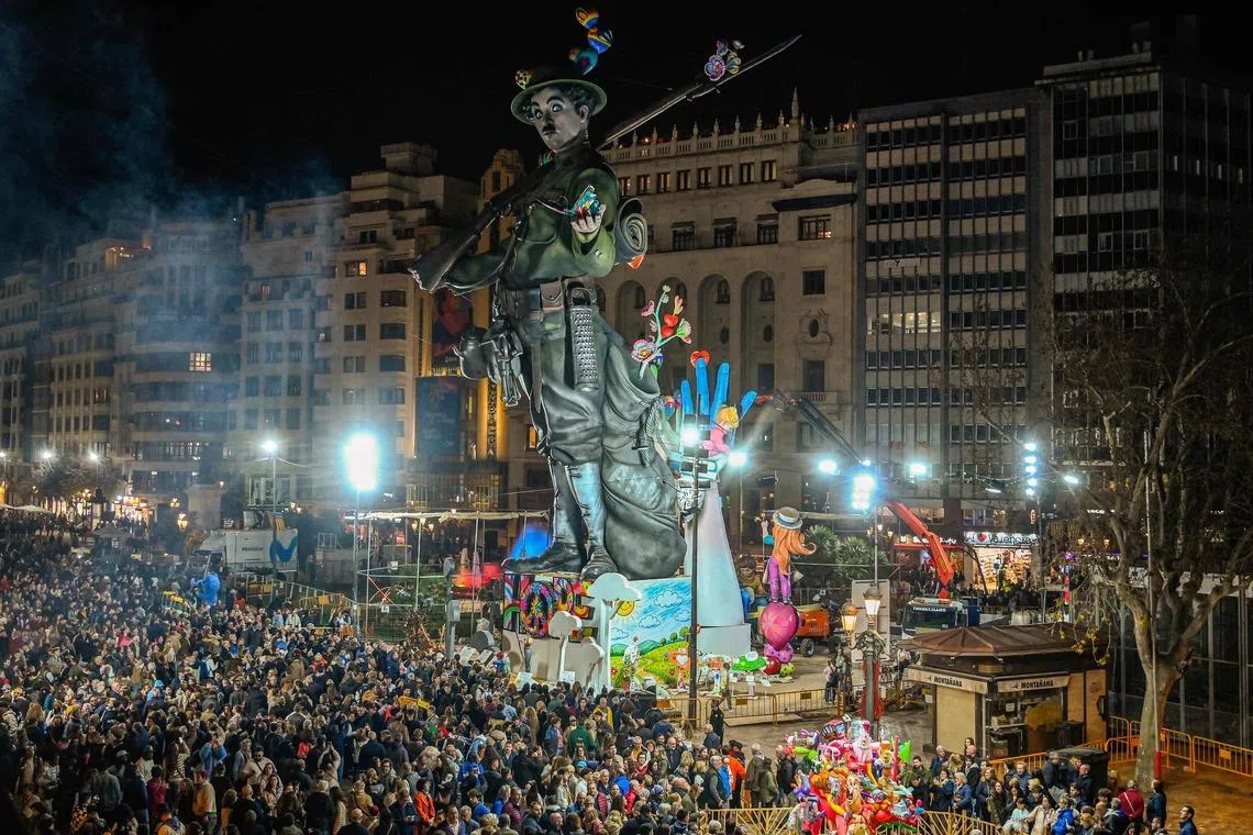People gather to view the 'fallas', gigantic cardboard structures depicting current events and celebrities, with individual figures known as 'ninots' on March 15, 2026. Fallas are burned in the streets of Valencia every year on March 19 as a tribute to San Jose (Saint Joseph), patron saint of the carpenters' guild. The Fallas festival was added to UNESCO's intangible cultural heritage of humanity list in 2016. (Photo by JOSE JORDAN / AFP)