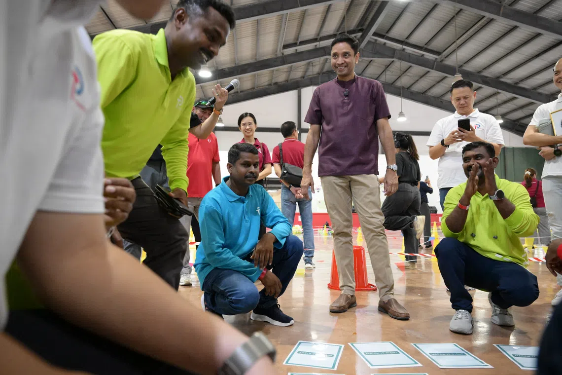 Minister of State for Manpower Dinesh Vasu Dash (in purple) engaging in a game with migrant workers at Terusan Recreation Centre on Oct 5.