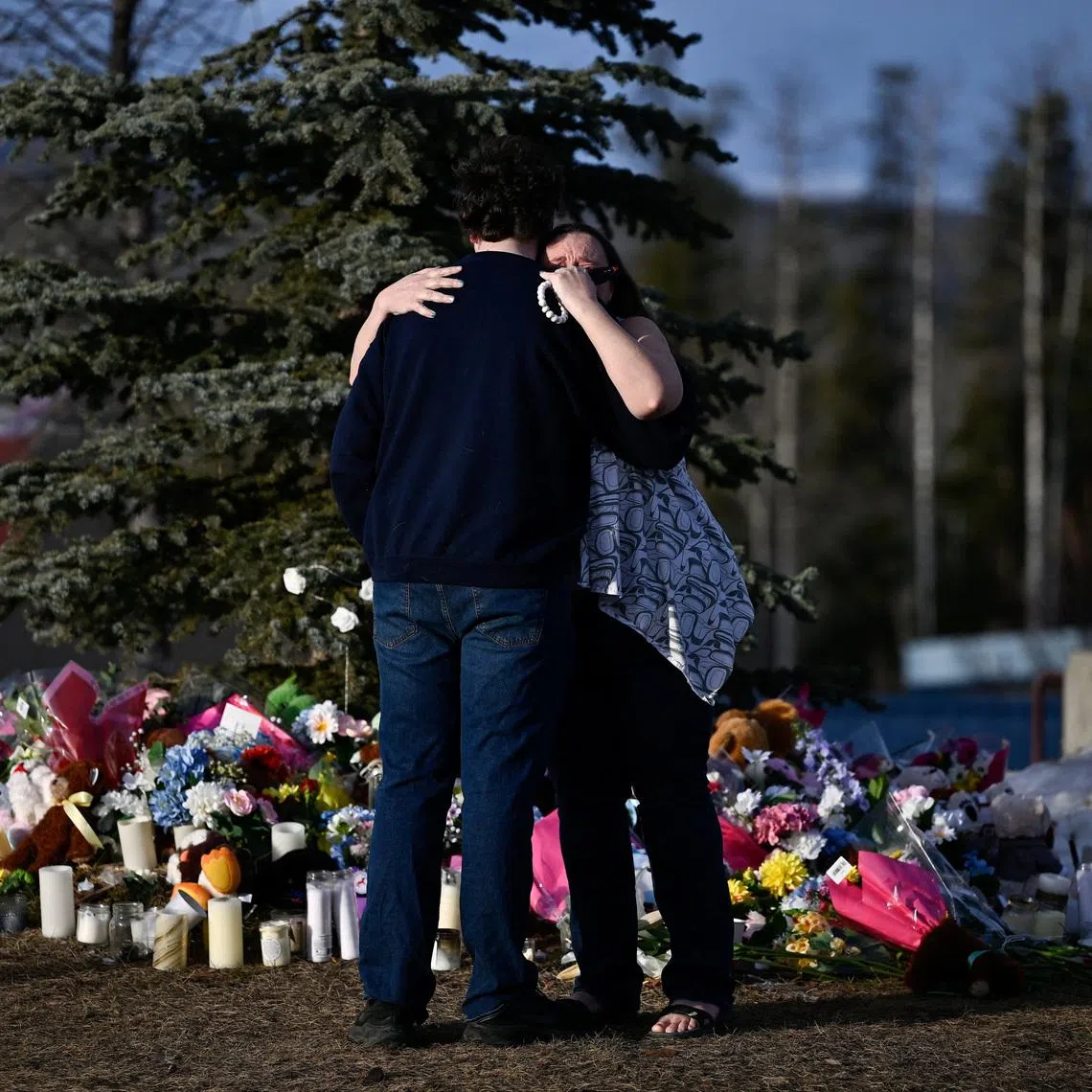 Student Darian Quist and Shelley Quist embrace next to a makeshift memorial for the victims two days after a deadly mass shooting took place at a school, in the town of Tumbler Ridge, British Columbia, Canada February 12, 2026. REUTERS/Jennifer Gauthier     TPX IMAGES OF THE DAY