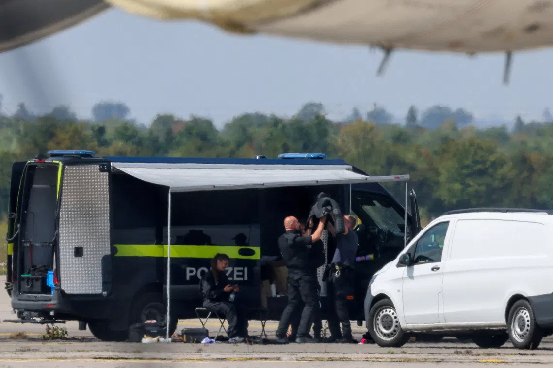 Police officers work in the vicinity of an Antonov cargo plane, near which a drone was found at Leipzig/Halle Airport in Schkeuditz, Germany, on Aug 5.