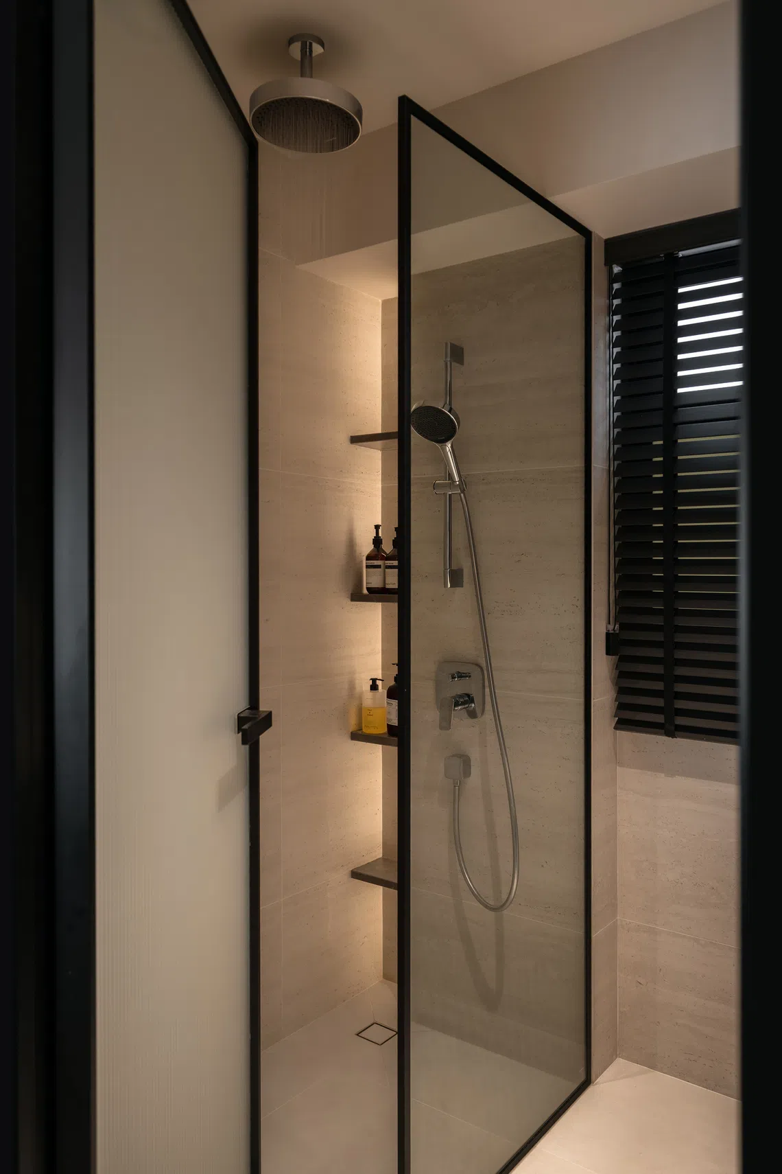 Soft lighting, wall niches and muted finishes transform the master bathroom into a spa-like retreat.
