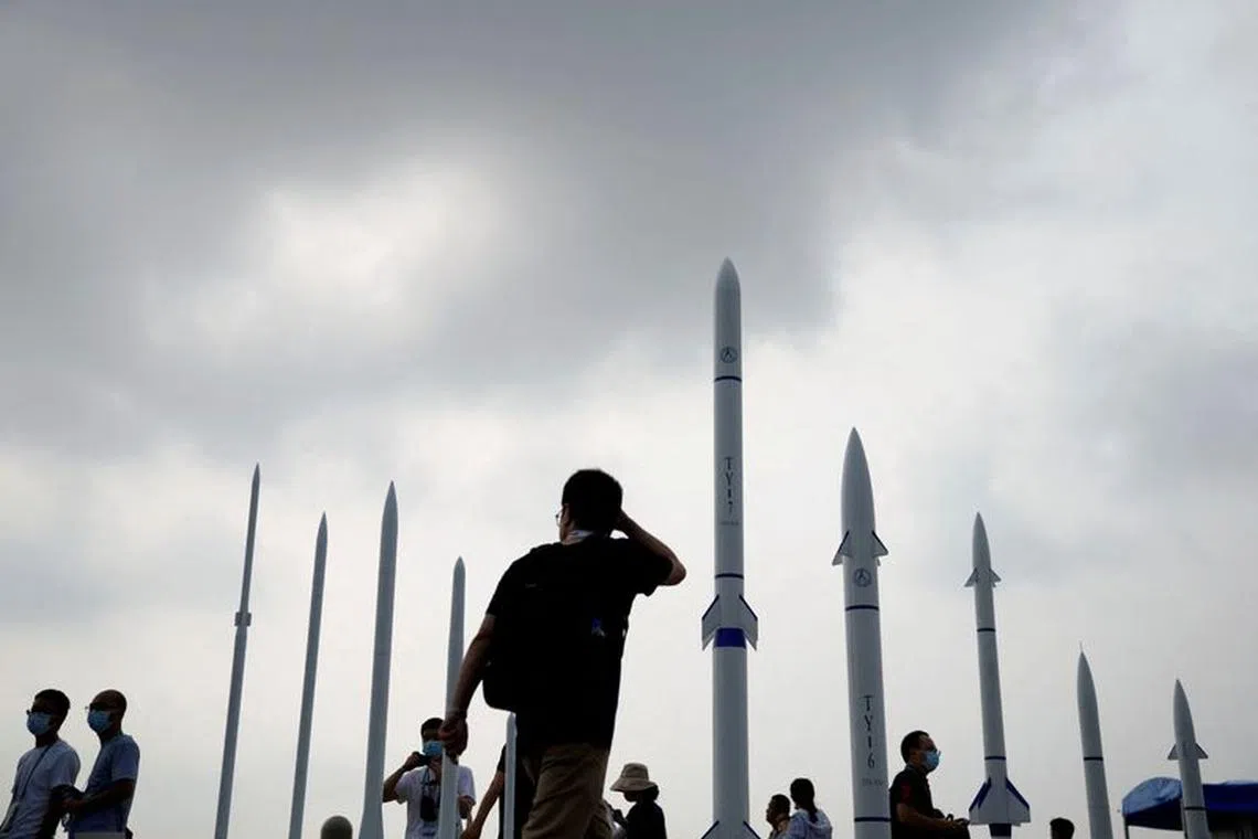 FILE PHOTO: People walk past sounding rockets displayed at the China International Aviation and Aerospace Exhibition, or Airshow China, in Zhuhai, Guangdong province, China September 29, 2021. REUTERS/Aly Song/File Photo