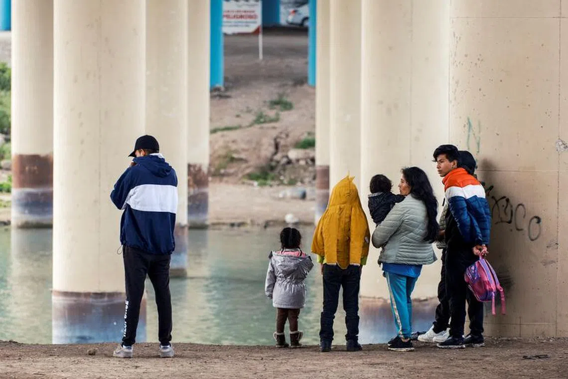 FILE PHOTO:A family from Ecuador walks towards Border Patrol officers to seek asylum, as U.S. border cities brace for an influx of asylum seekers as COVID-era Title 42 migration restrictions are set to end, in Eagle Pass, Texas, U.S. December 19, 2022.  REUTERS/Jordan Vonderhaar/File Photo