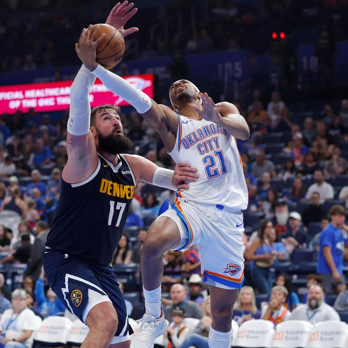 Oklahoma City Thunder guard Aaron Wiggins goes up for a basket in front of Denver Nuggets center Jonas Valanciunas during a pre-season game.