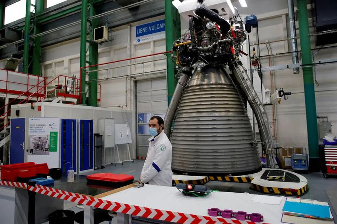 FILE PHOTO: A worker of Ariane Group stands in front of a Ariane 6 rocket's Vulcain 2.1 engine, prior to the visit of French President Emmanuel Macron, in Vernon, France January 12, 2021. Christophe Ena/Pool via REUTERS/File Photo