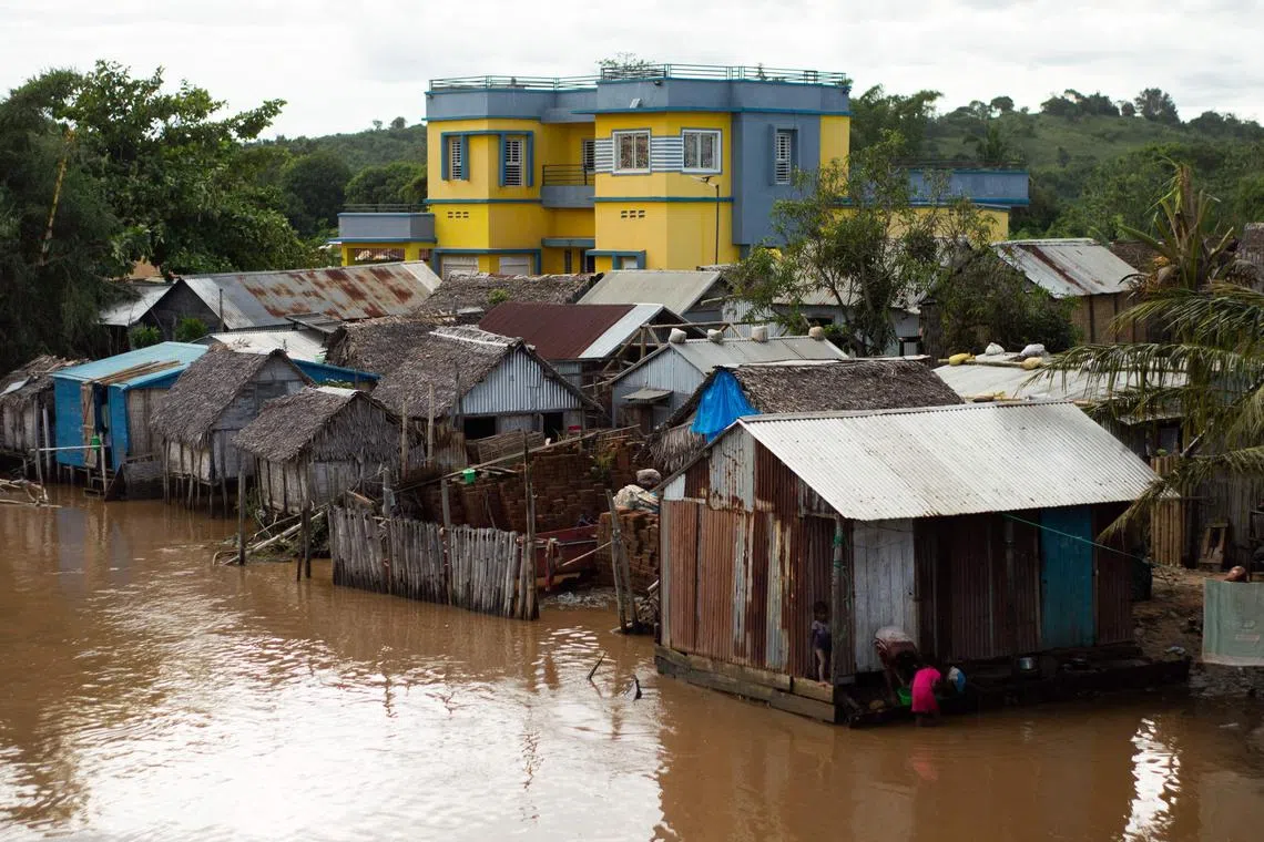 Residents try to resume their daily life in their house submerged by water in Sambava, Madagascar, on Jan 21, 2023.