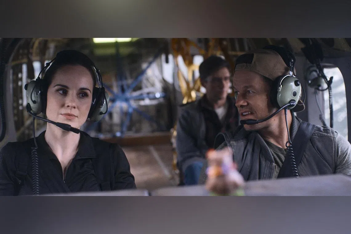 Michelle Dockery (foreground left),  Mark Wahlberg and Topher Grace (background) in Flight Risk.