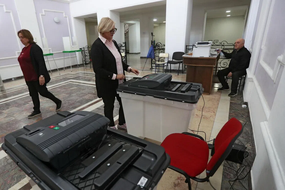 A member of an electoral commission checks a ballot box at a polling station on the eve of the parliamentary elections in Tbilisi, Georgia October 25, 2024. REUTERS/Irakli Gedenidze