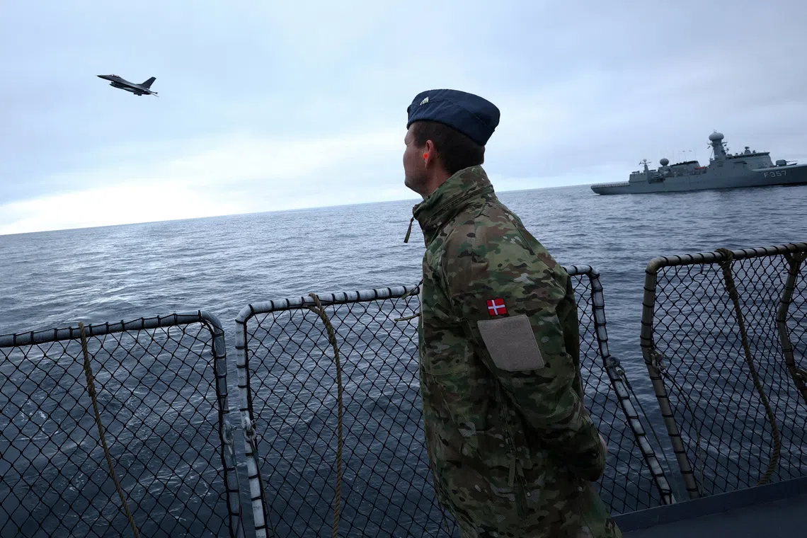 A Danish F-16 fighter jet flies over the frigate Niels Juel as Danish and French armed forces perform military drills off the coast of Nuuk, Greenland, September 15, 2025. REUTERS/Guglielmo Mangiapane