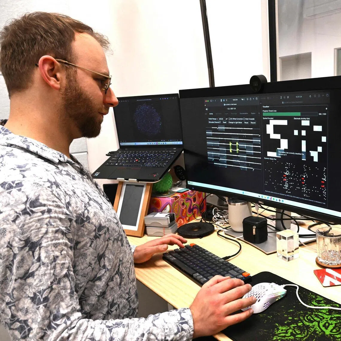 Chief scientific and operations officer Brett Kagan looks at cortical and hippocampal cells on cell culture plates as they attempt to decode morse code, at Cortical Labs' Physical Containment Level 2 (PC2) laboratory in Melbourne. 
