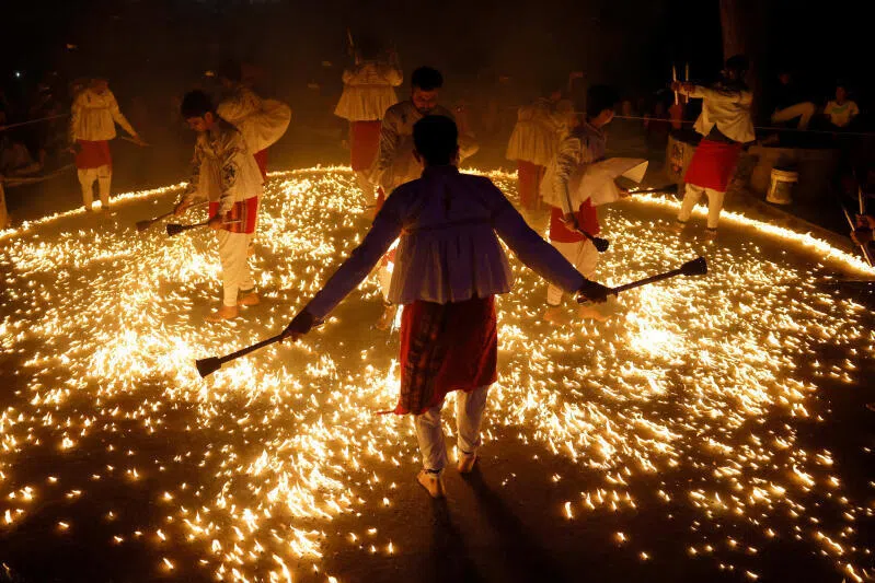 Hindu devotees performing Garba, a traditional folk dance, barefooted on tiny cotton fire balls spread inside a ring, as part of the Navratri festival celebrations, in Jamnagar, Gujarat, India, on Sept 25, 2025.