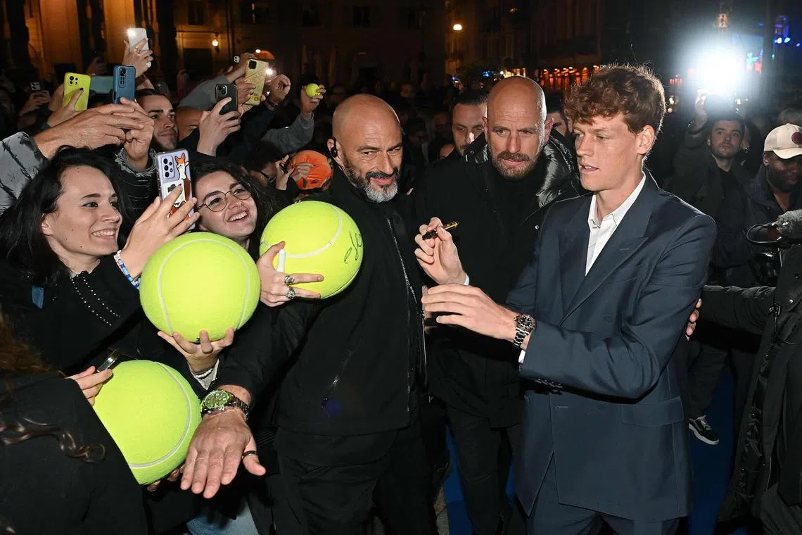 Jannik Sinner signs autographs for fans as he prepares to compete at the ATP Finals in Turin.