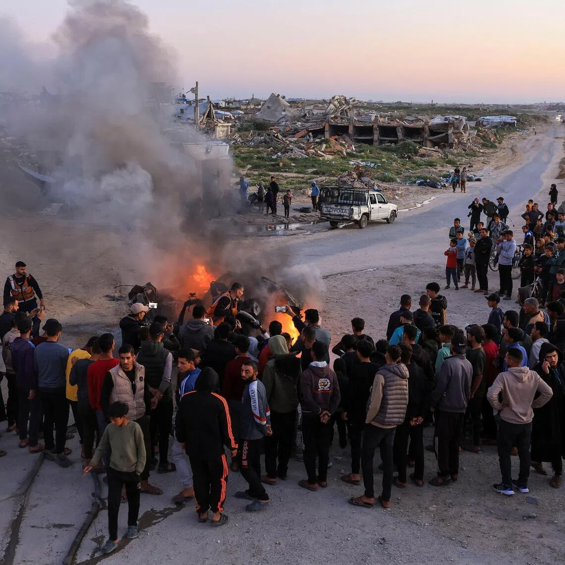 Rescuers working to extinguish a fire following an Israeli strike on a vehicle that killed an Al Jazeera journalist, according to medics, in Gaza City on April 8.