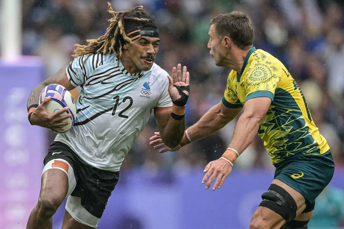 Fiji's Selesitino Ravutaumada (left) is chased by Australia's Nathan Lawson during an Olympics rugby sevens semi-final.