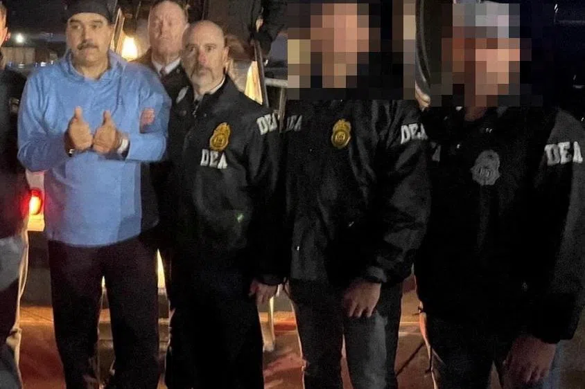 Venezuela's captured President Nicolas Maduro poses next to U.S. Drug Enforcement Administration (DEA) administrator Terry Cole as he is led in custody from a U.S. federal airplane, at Stewart Air National Guard Base in Newburgh, New York, U.S., January 3, 2026.  Handout via REUTERS