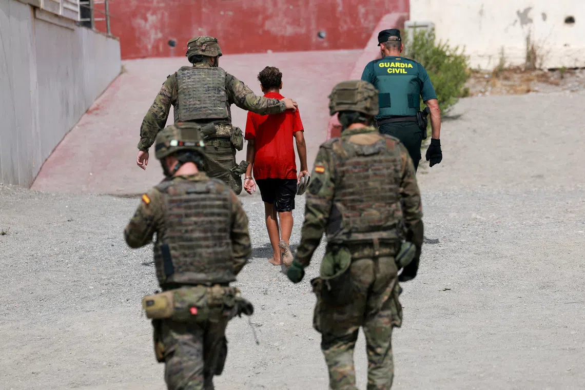 A migrant minor from Morocco is escorted by Spanish security forces after attempting to cross into Ceuta by sea amid recent mass crossings of migrants on foot and by sea from Morocco into Spanish territory, in Ceuta, Spain, August 1, 2026. REUTERS/Violeta Santos Moura