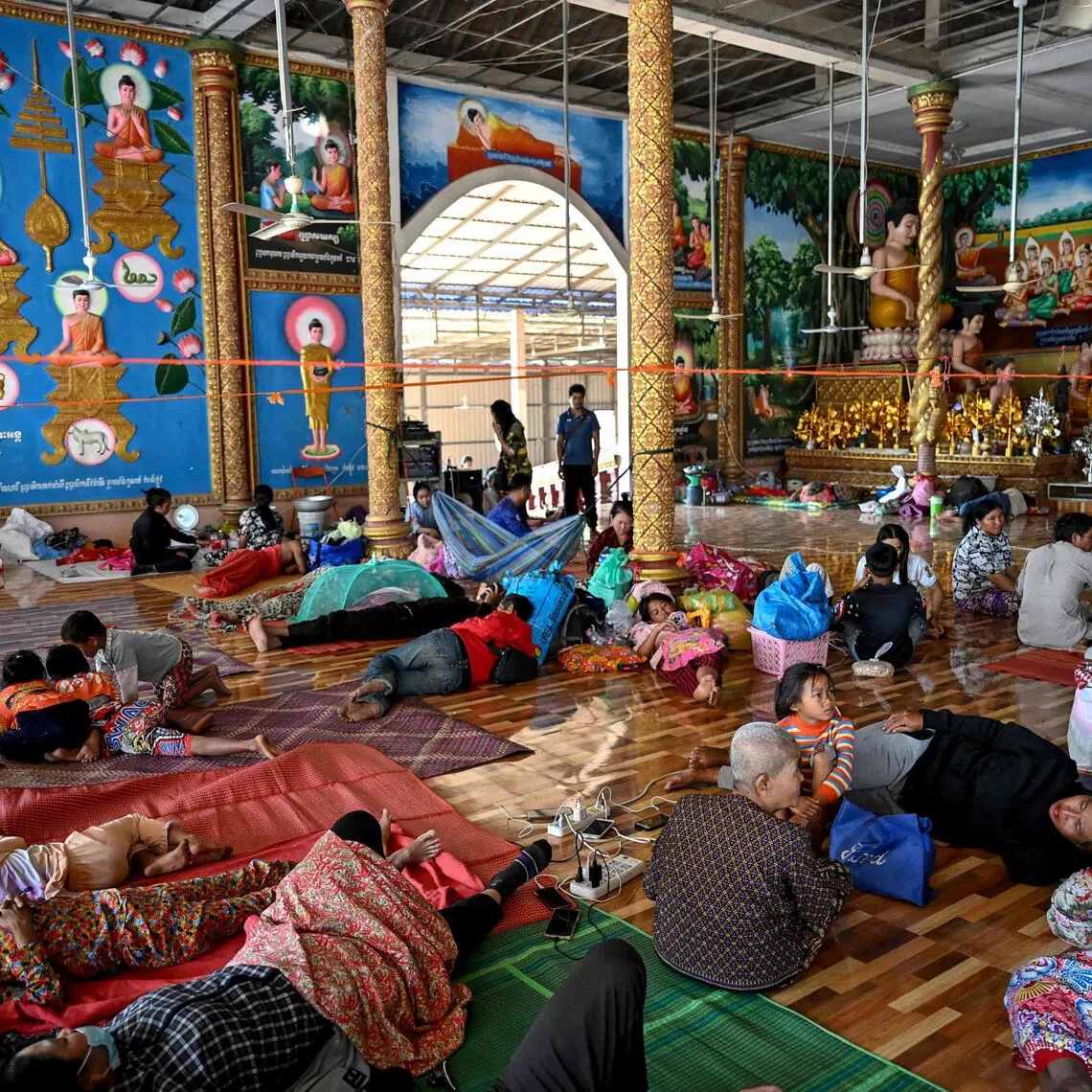 Cambodians rest inside a temple after they evacuated following clashes along the Cambodia-Thailand border, in Siem Reap, on Dec 9.