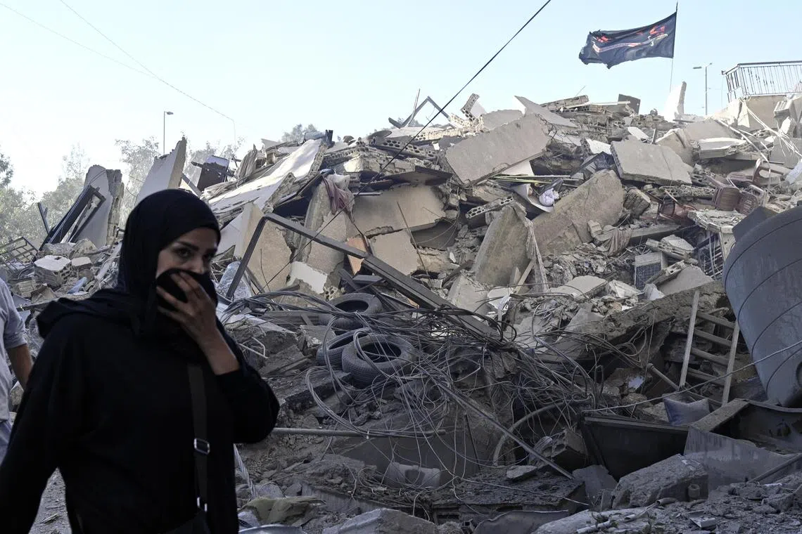 A woman walking past the rubble of a damaged structure, following an Israeli airstrike south of Beirut, Lebanon, on Oct 22.