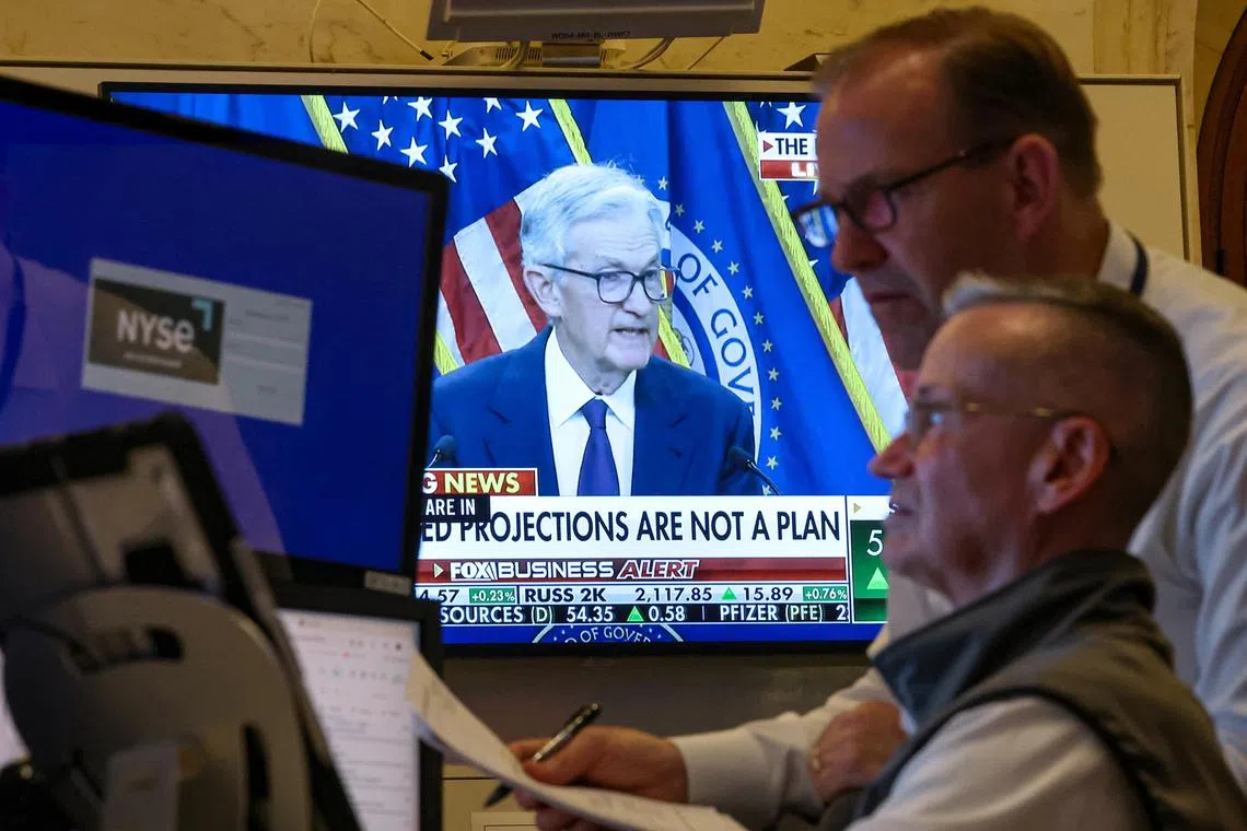 Traders working on the floor of the New York Stock Exchange, as a screen broadcasts a news conference by US Federal Reserve chairman Jerome Powell on June 18.