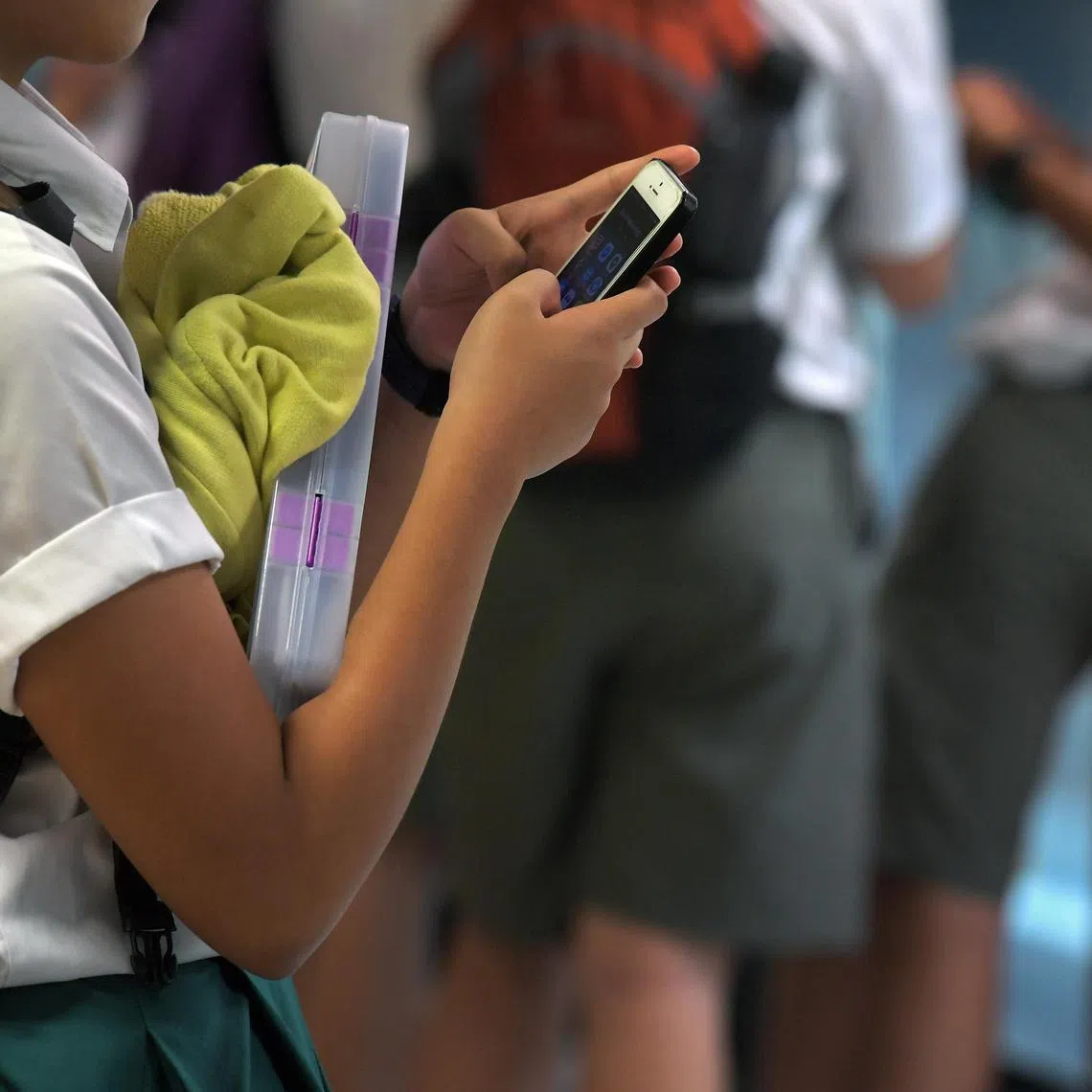 Students using their mobile phones at Bishan MRT station on 23 February 2017.