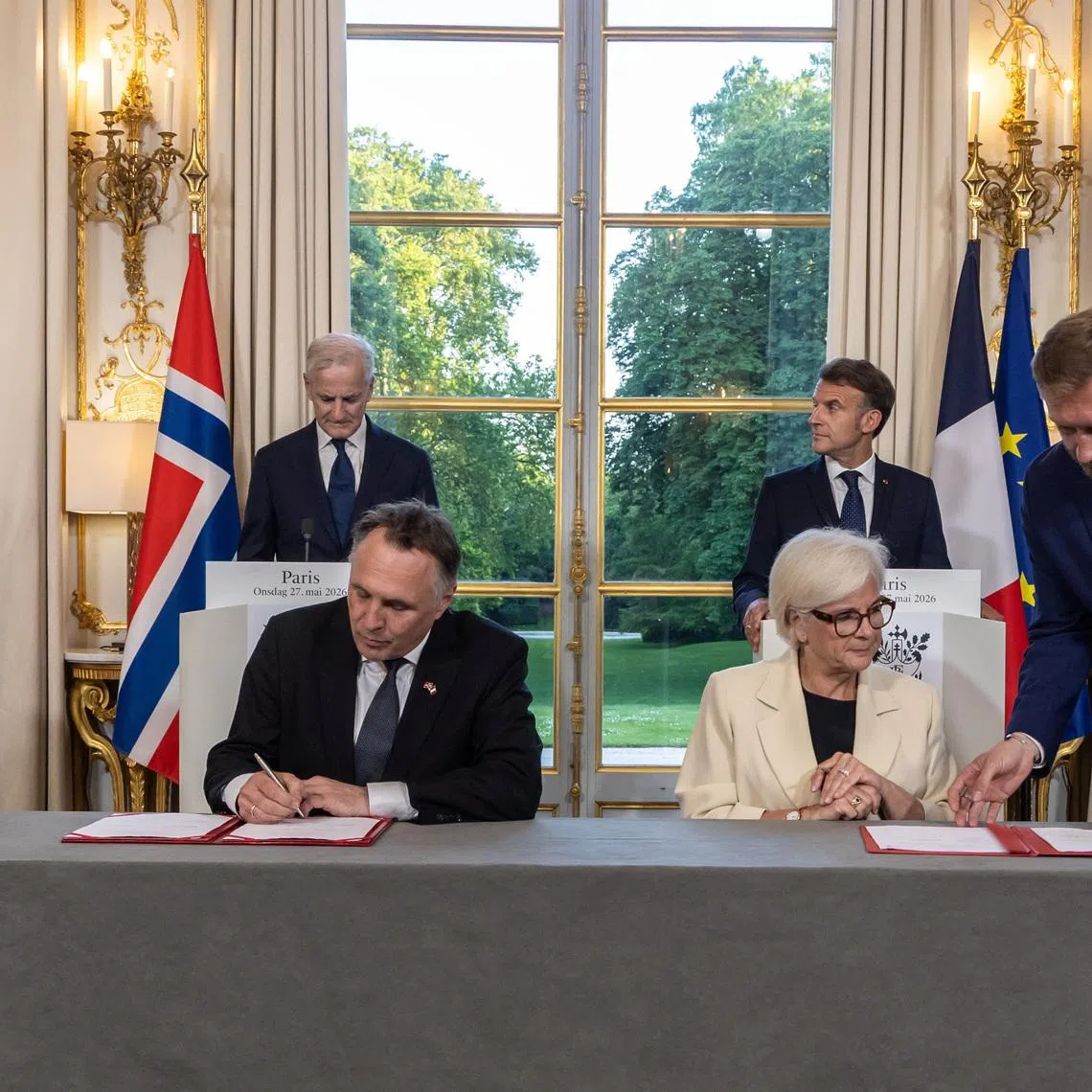 France's President Emmanuel Macron and Norway's Prime Minister Jonas Gahr Stoere look as Norwegian Defense Minister Tore Sandvik and French Defence and Veterans Minister Catherine Vautrin sign an agreement prior to a working dinner at the Elysee Palace in Paris, France, 27 May 2026.  CHRISTOPHE PETIT TESSON/Pool via REUTERS