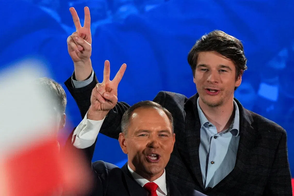 Polish presidential candidate Karol Nawrocki, backed by the main opposition Law and Justice (PiS) party, and his son Antoni, show a victory sign as they react to the exit polls of the second round of the presidential election, in Warsaw, Poland, June 1, 2025. REUTERS/Aleksandra Szmigiel